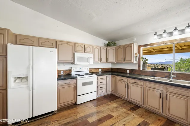 a kitchen with a sink a refrigerator and cabinets