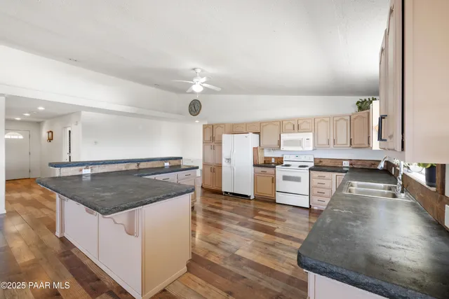 a kitchen with stainless steel appliances granite countertop a lot of counter space and wooden floor