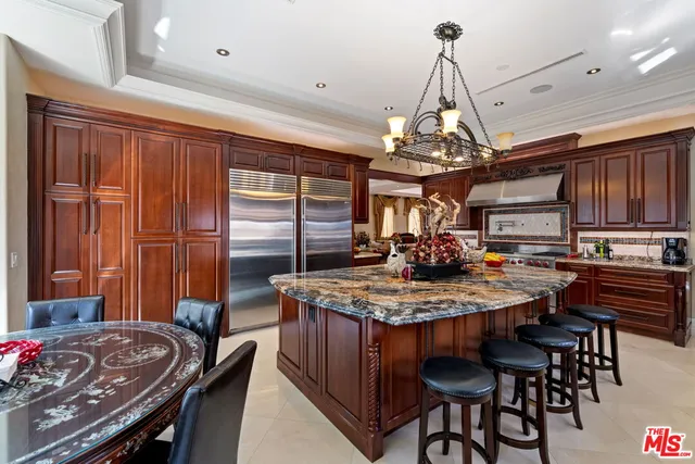 a kitchen with kitchen island granite countertop a sink cabinets and stainless steel appliances