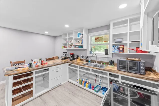a kitchen that has a lot of cabinets in it and wooden floor