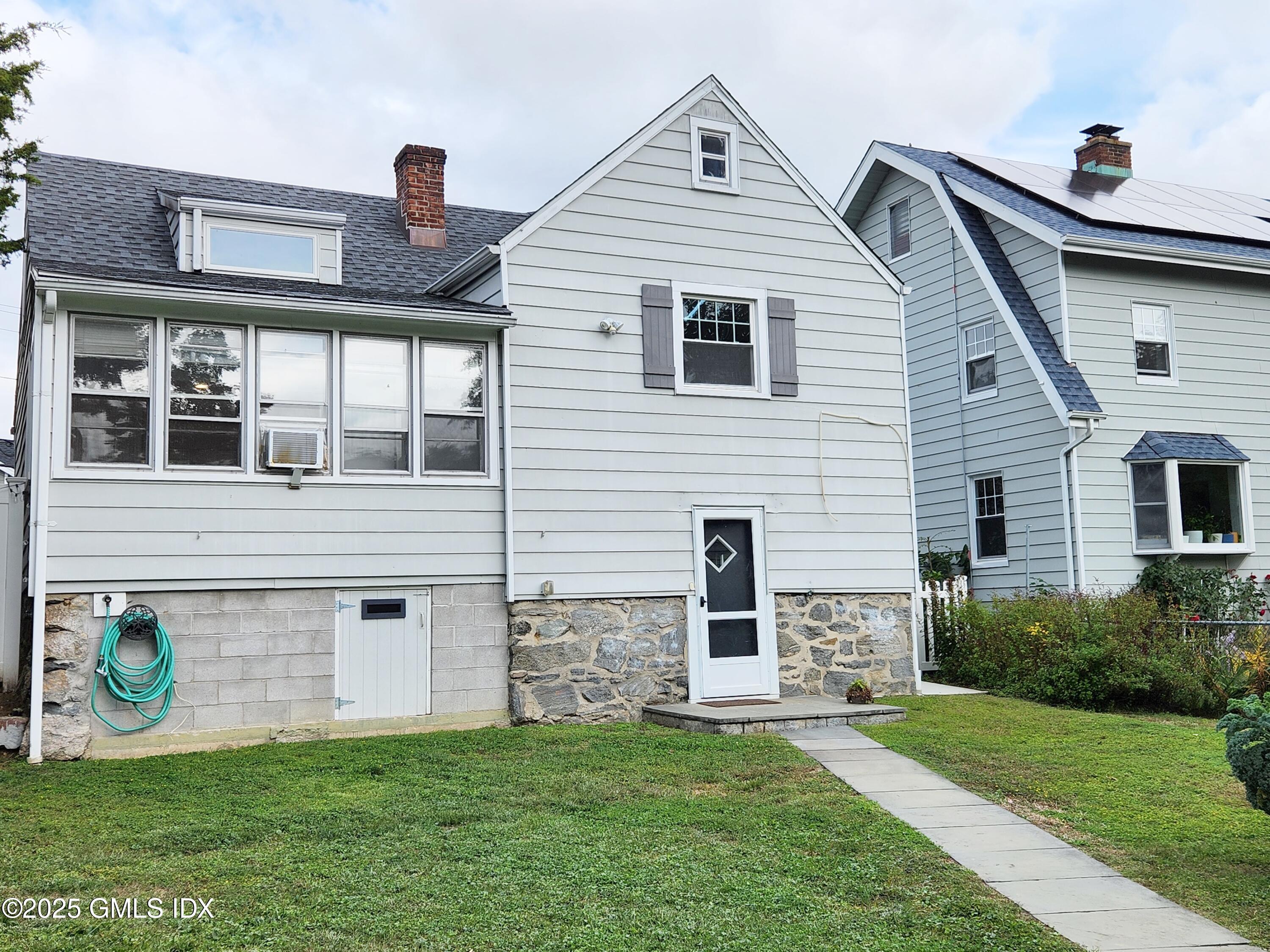 13 High Street Greenwich, CT 06830 - Photo 27 of 29 a front view of a house with a garden and plants