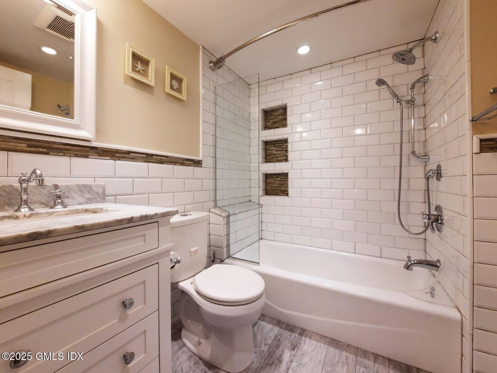 13 High Street Greenwich, CT 06830 - Photo 3 of 29 a bathroom with a bathtub shower sink vanity mirror and toilet