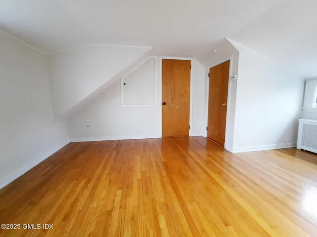an empty room with wooden floor and entrance