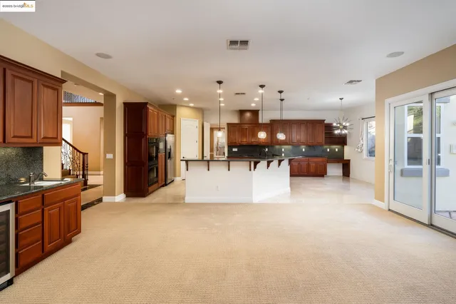 a large white kitchen with kitchen island a stove a refrigerator a sink and a counter top space