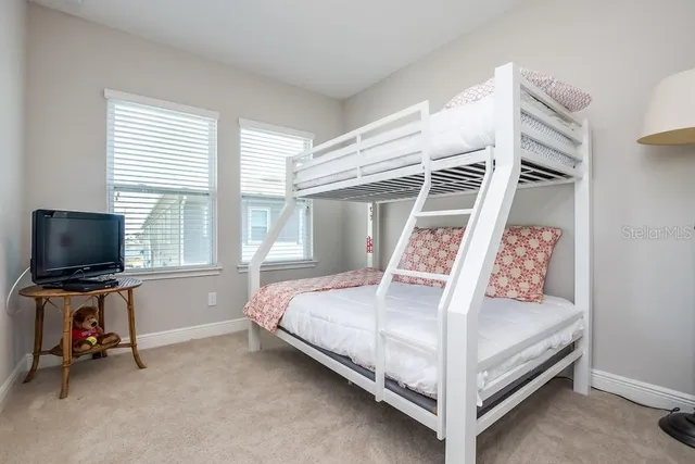 a bedroom with a bed and flat tv screen
