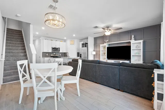 a view of a dining room with furniture a chandelier and wooden floor