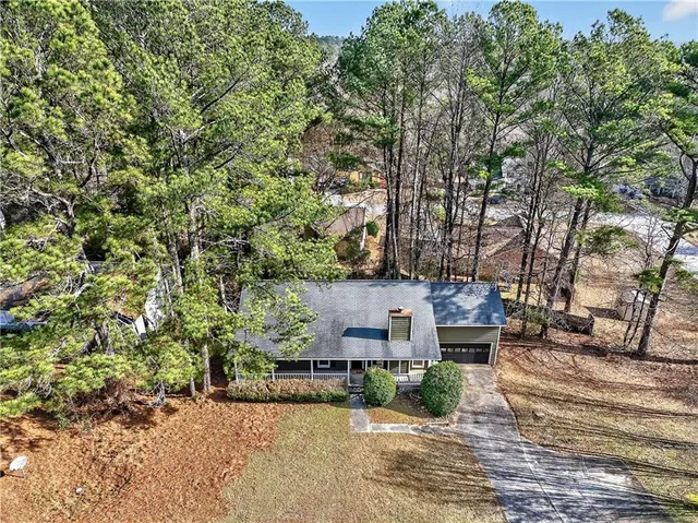 an aerial view of a house with a yard and large trees
