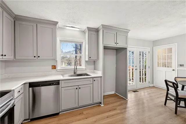 a kitchen with a sink cabinets and wooden floor