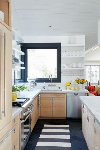 a kitchen with a sink window and cabinets