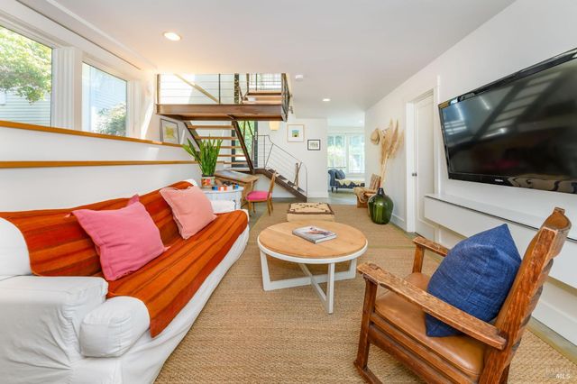a living room with furniture a flat screen tv and kitchen view