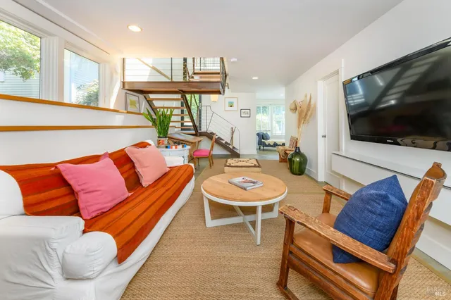 a living room with furniture a flat screen tv and kitchen view