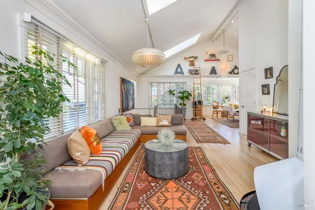 a living room with furniture kitchen view and a large window