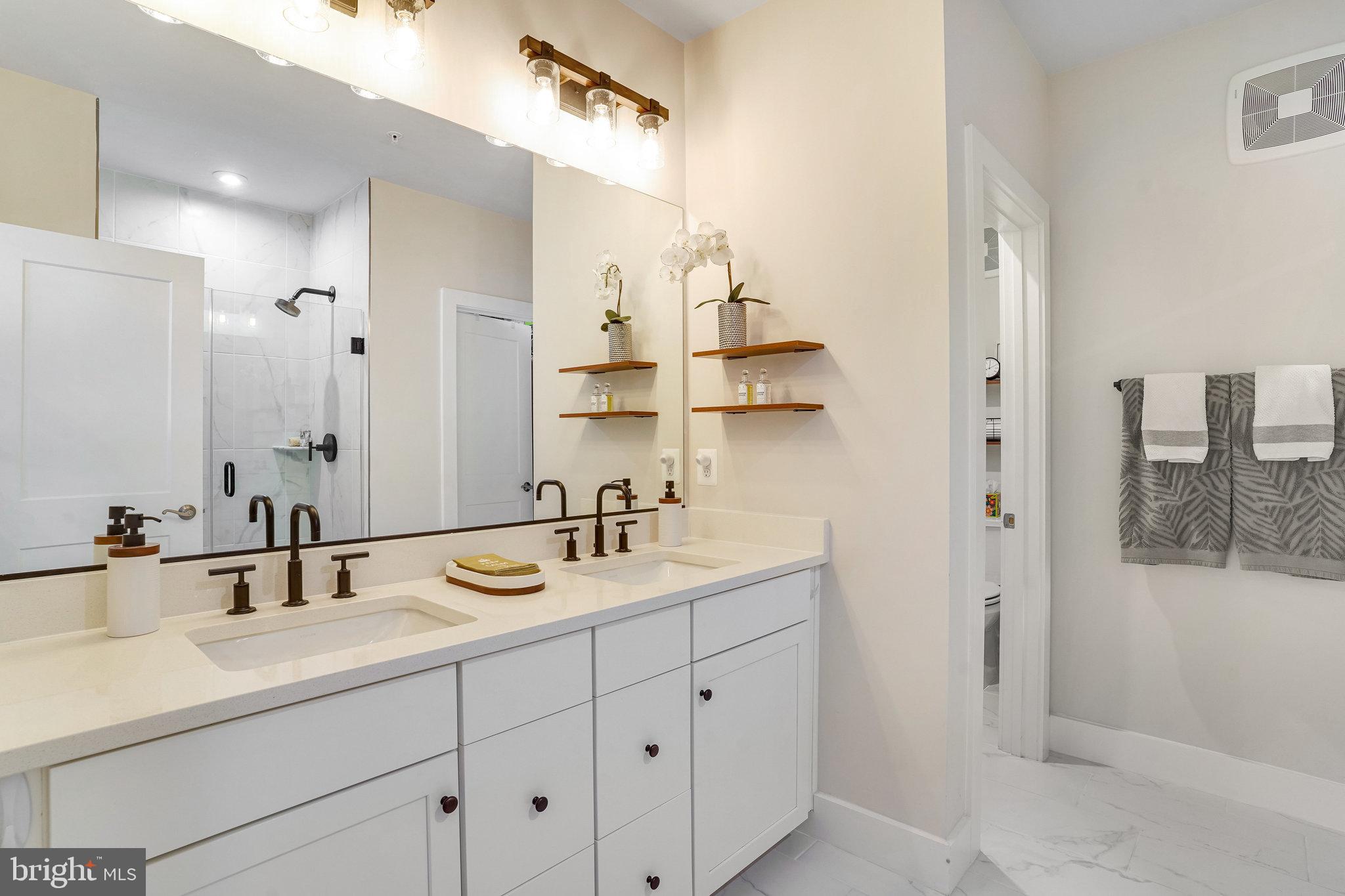 1660 Bandit Loop Reston, VA 20190 - Photo 16 of 39 a bathroom with a double vanity sink a mirror and shower