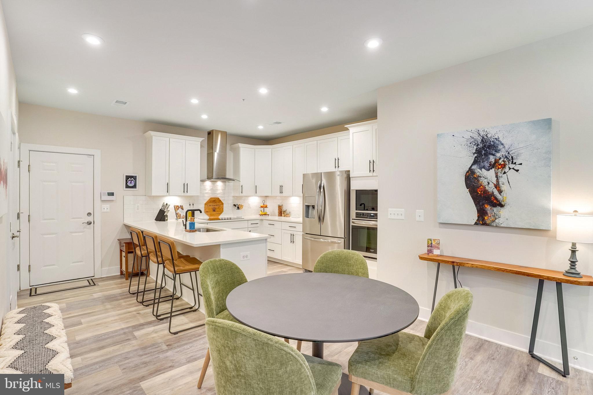 1660 Bandit Loop Reston, VA 20190 - Photo 6 of 39 a open dining room with stainless steel appliances kitchen island granite countertop a dining table chairs and a refrigerator