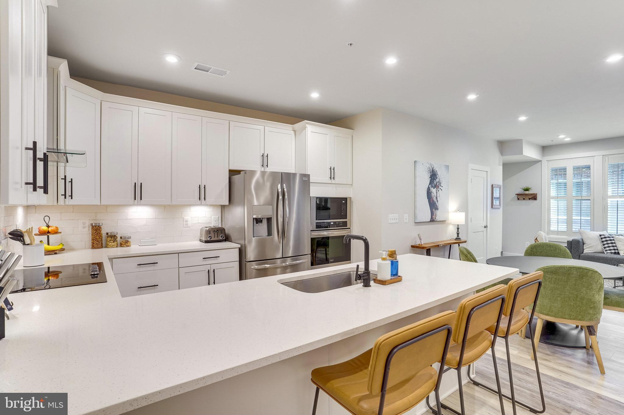 1660 Bandit Loop Reston, VA 20190 - Photo 9 of 39 a kitchen with stainless steel appliances kitchen island granite countertop a kitchen island a stove a table and chairs