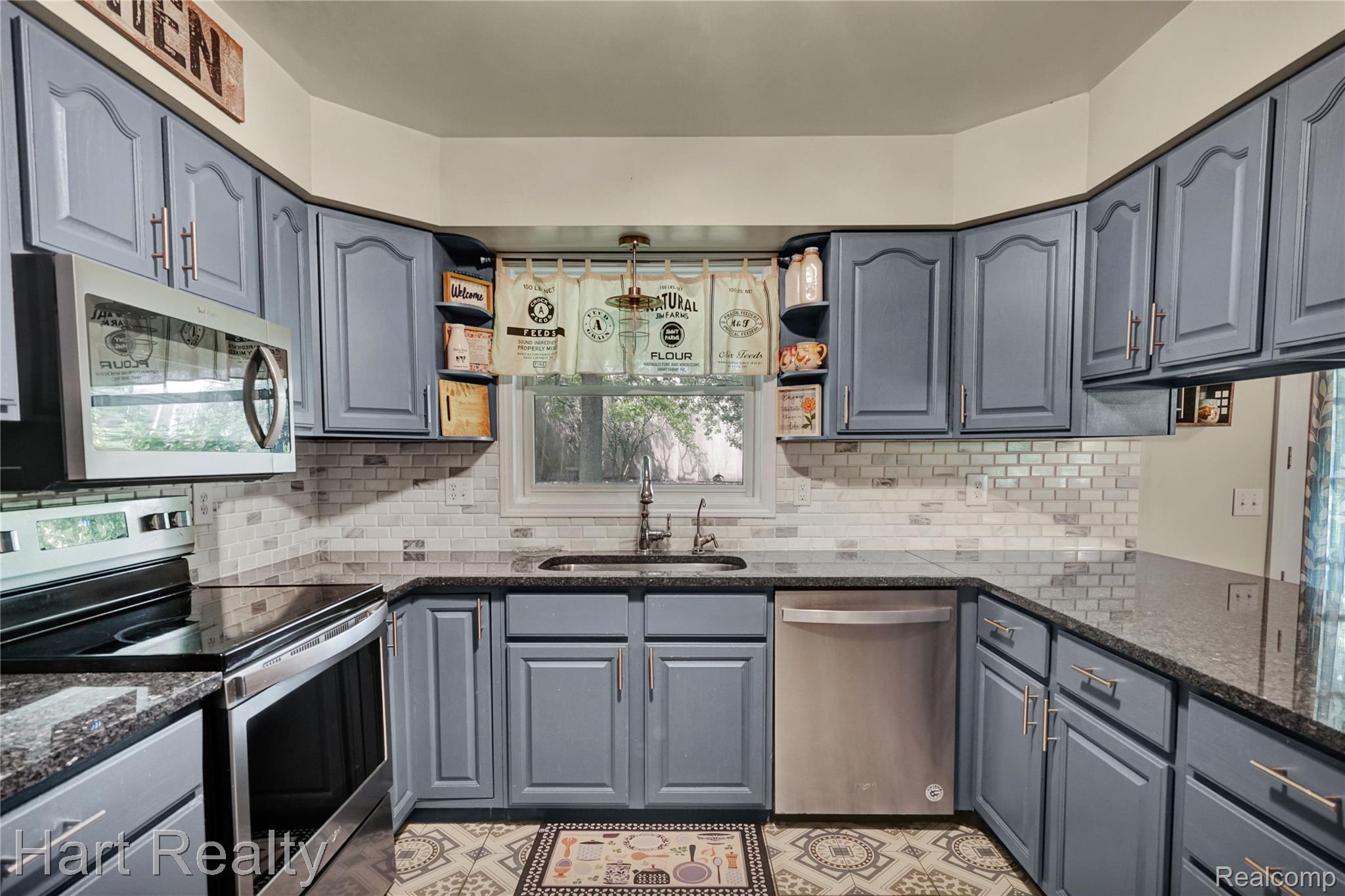 7167 Brown School Road North Branch, MI 48461 - Photo 17 of 51 Kitchen featuring blue cabinetry, dark countertops, white subway tile backsplash, and stainless steel appliances