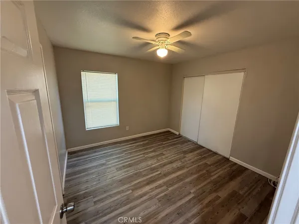 a view of empty room with window and wooden floor