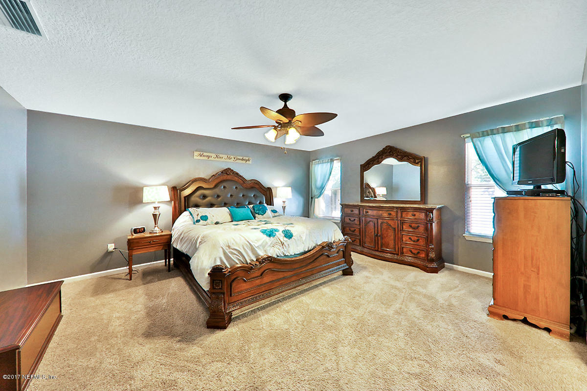 757 MacKenzie Circle St. Augustine, FL 32092 - Photo 13 of 31 a bedroom with a bed window and a flat tv screen on dresser