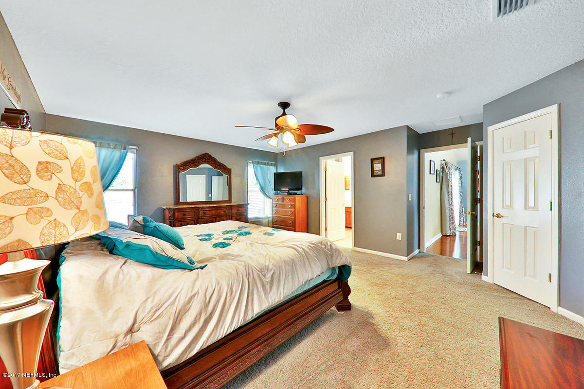 757 MacKenzie Circle St. Augustine, FL 32092 - Photo 14 of 31 a bedroom with a bed and a chandelier