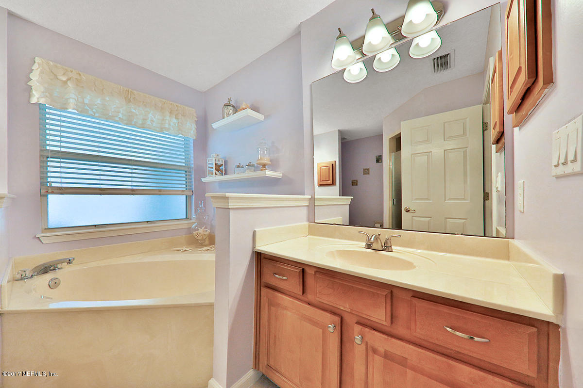 757 MacKenzie Circle St. Augustine, FL 32092 - Photo 16 of 31 a bathroom with a granite countertop sink a large mirror and a bathtub