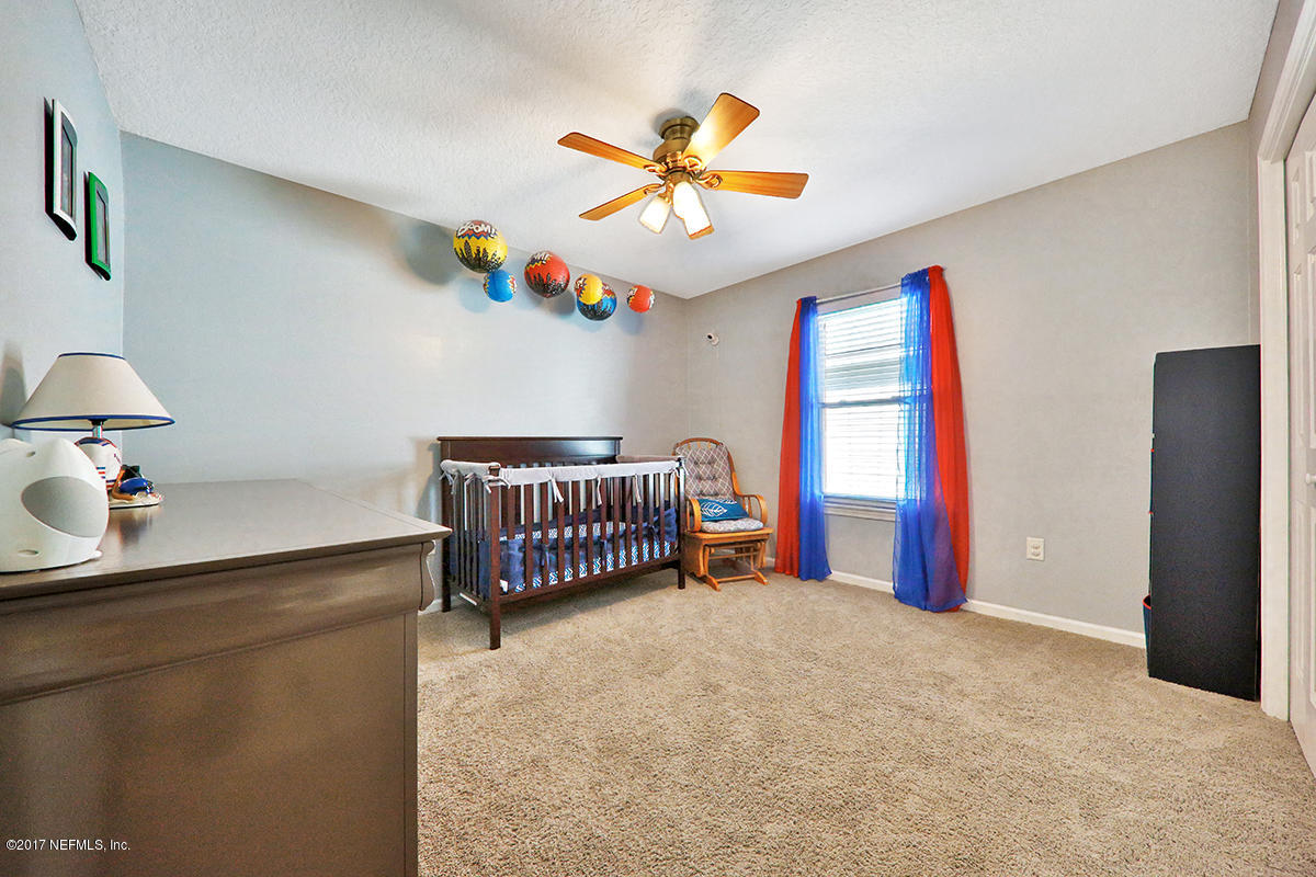 757 MacKenzie Circle St. Augustine, FL 32092 - Photo 19 of 31 a bedroom with a bed and a chandelier