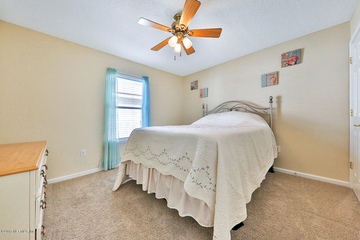 757 MacKenzie Circle St. Augustine, FL 32092 - Photo 25 of 31 a spacious bedroom with a bed and a chandelier