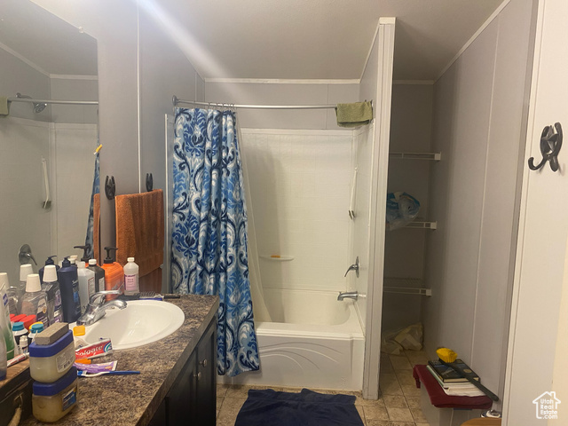 4963 20810 West Duchesne, UT 84021 - Photo 4 of 28 Bathroom with shower / bathtub combination with curtain, vanity, light tile patterned floors, and ornamental molding