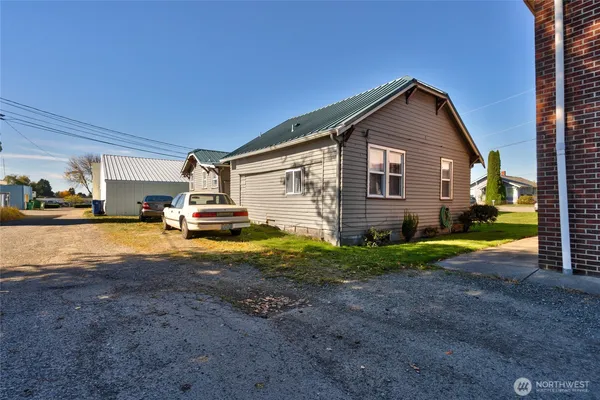 a view of backyard of house and car parked