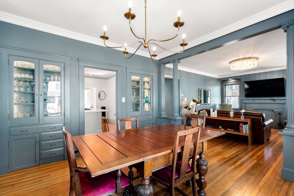 271 Atlantic Street Quincy, MA 02171 - Photo 15 of 24 a dining room with wooden floor a chandelier a wooden table and chairs