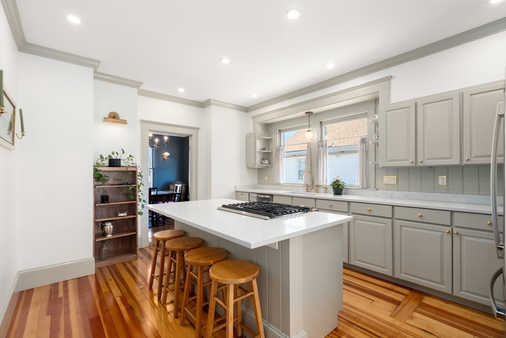 271 Atlantic Street Quincy, MA 02171 - Photo 5 of 24 a kitchen that has a sink a stove and chairs