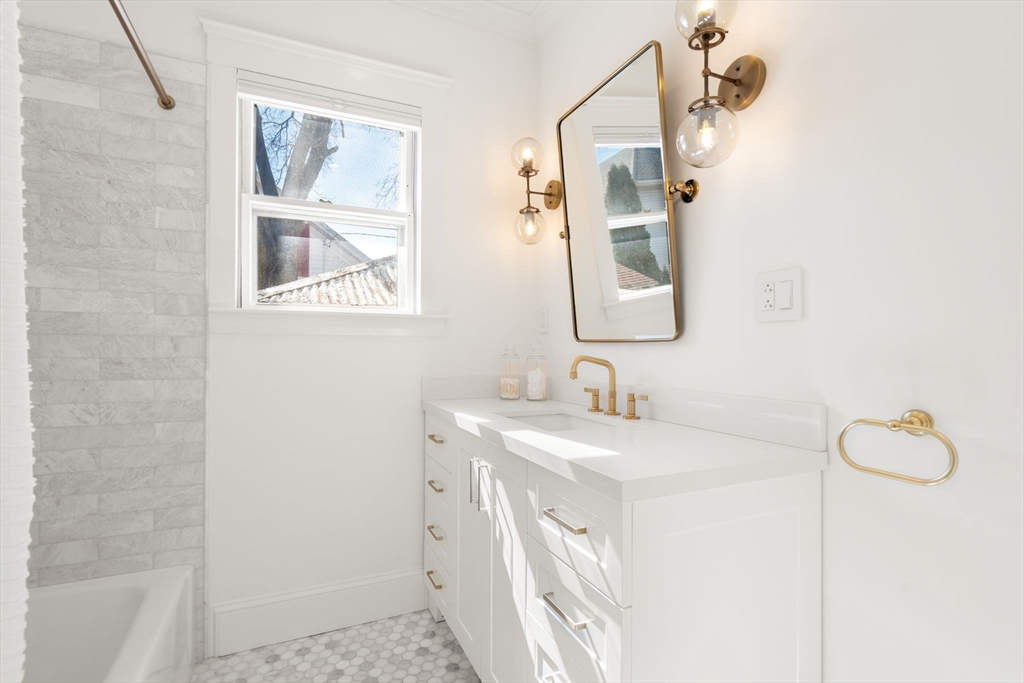 271 Atlantic Street Quincy, MA 02171 - Photo 9 of 24 a bathroom with a sink and a mirror