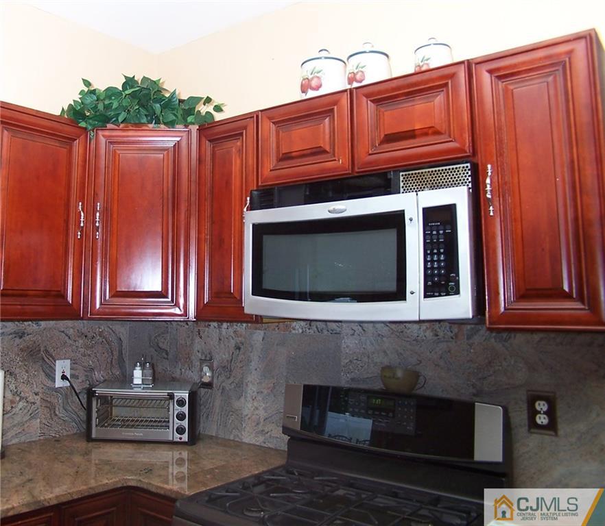 6 Nutmeg Road Aberdeen, NJ 07747 - Photo 14 of 24 a kitchen with granite countertop wooden cabinets and a stove top oven