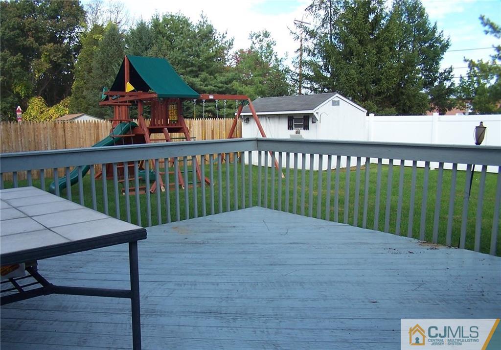 6 Nutmeg Road Aberdeen, NJ 07747 - Photo 21 of 24 a view of a wooden deck that has a yard