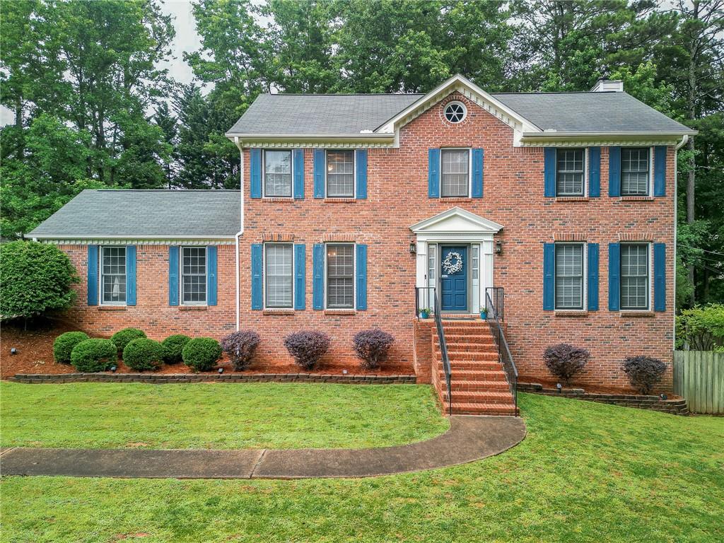 a front view of a house with a yard and outdoor seating