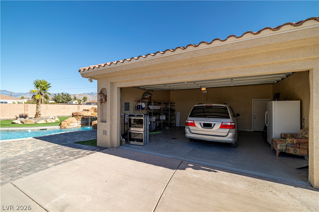 2181 Winery Road Pahrump, NV 89048 - Photo 49 of 52 A spacious garage with concrete flooring provides ample parking, complementing the additional living space in the back of the garage. 400 sq ft of double insulation and drywall for those Musically inclined space needs. Or remove the wall and open it up to an impressive cooled 4 car garage!