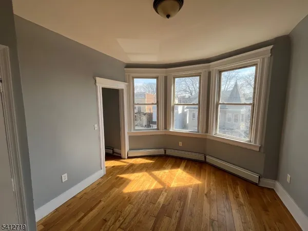an empty room with a window and wooden floor