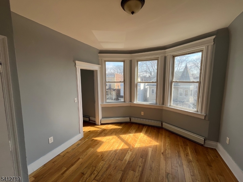 159 21st Street, Unit 2 Irvington, NJ 07111 - Photo 8 of 9 an empty room with a window and wooden floor