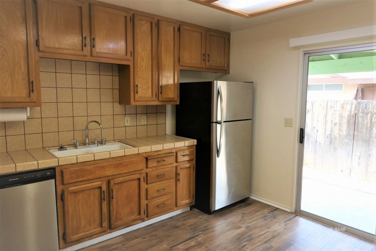 933 West Perdew Avenue Ridgecrest, CA 93555 - Photo 10 of 21 a kitchen with a refrigerator sink and cabinets