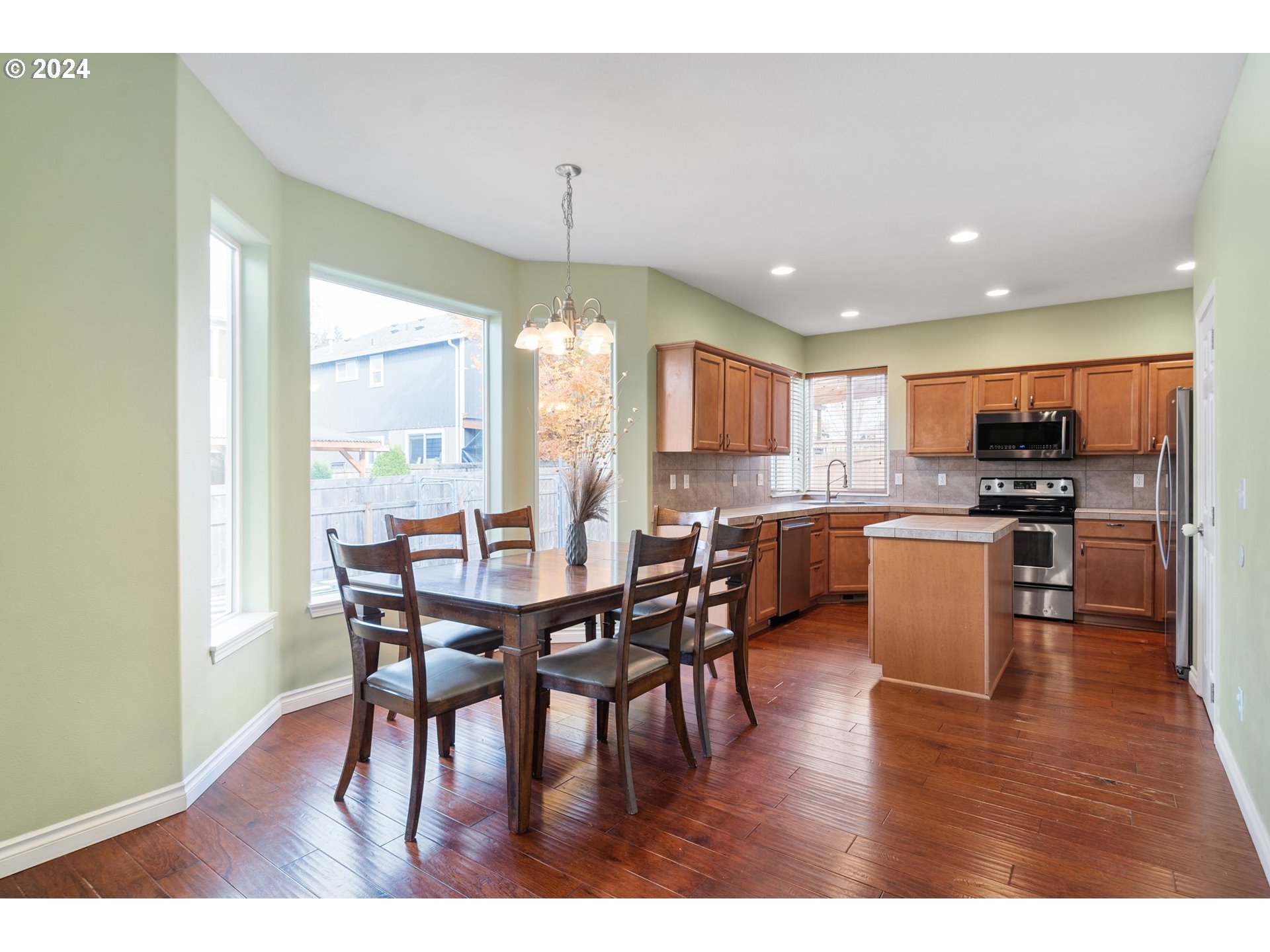 39833 Evans Street Sandy, OR 97055 - Photo 11 of 37 a open kitchen with stainless steel appliances granite countertop a dining table chairs refrigerator and sink