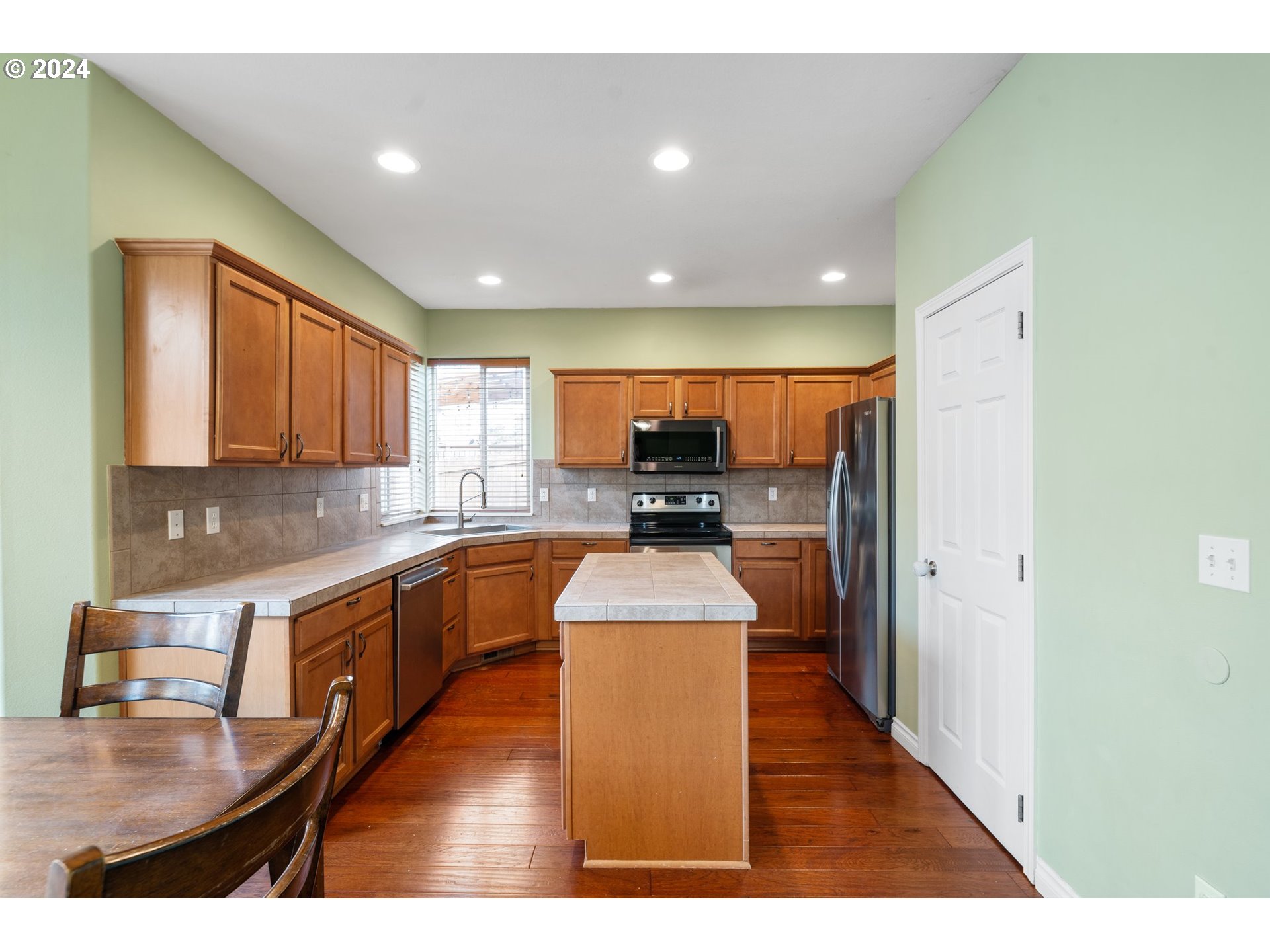 39833 Evans Street Sandy, OR 97055 - Photo 13 of 37 a kitchen with stainless steel appliances granite countertop a refrigerator a sink dishwasher a stove with wooden cabinets and floor
