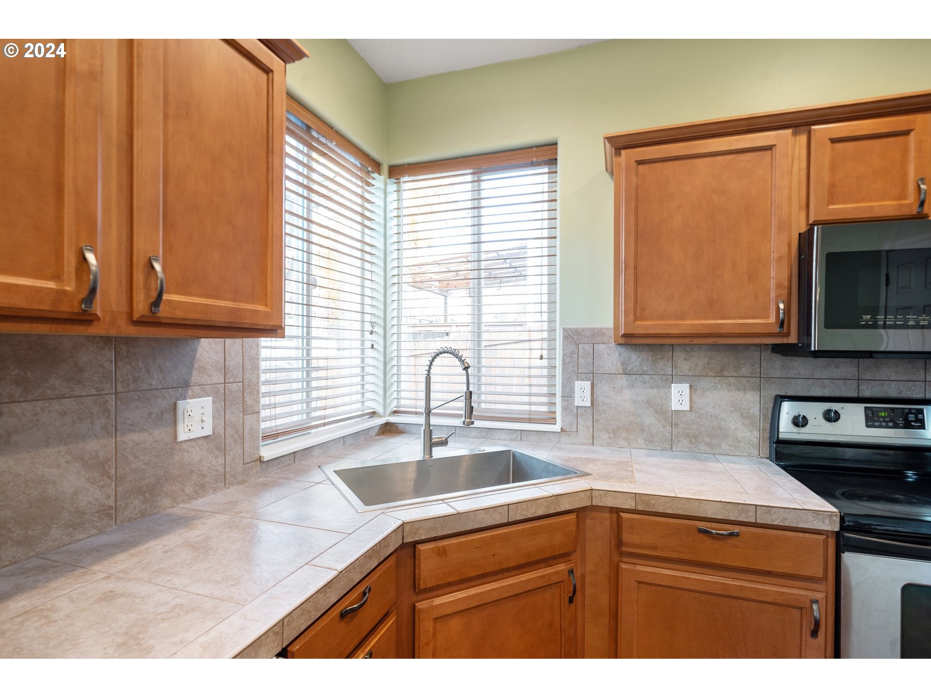 39833 Evans Street Sandy, OR 97055 - Photo 14 of 37 a kitchen with stainless steel appliances wooden cabinets a sink and a stove