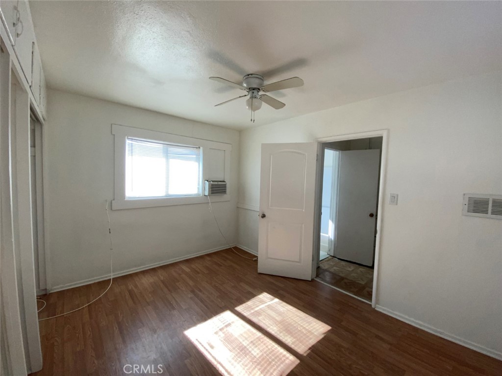 13193 Navajo Road, Unit 3 Apple Valley, CA 92308 - Photo 11 of 17 an empty room with wooden floor cabinet and windows