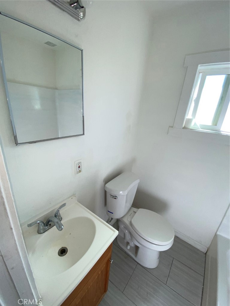 13193 Navajo Road, Unit 3 Apple Valley, CA 92308 - Photo 15 of 17 a white toilet sitting next to a bathroom sink