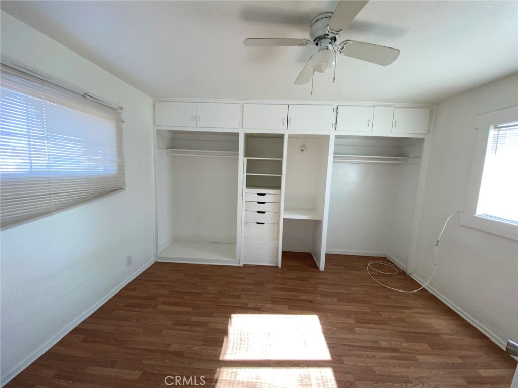 13193 Navajo Road, Unit 3 Apple Valley, CA 92308 - Photo 9 of 17 an empty room with wooden floor cabinet and windows