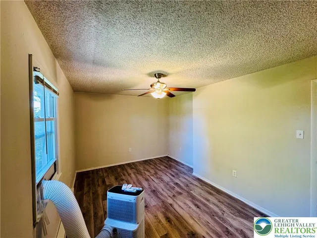 a view of a livingroom with wooden floor and a ceiling fan