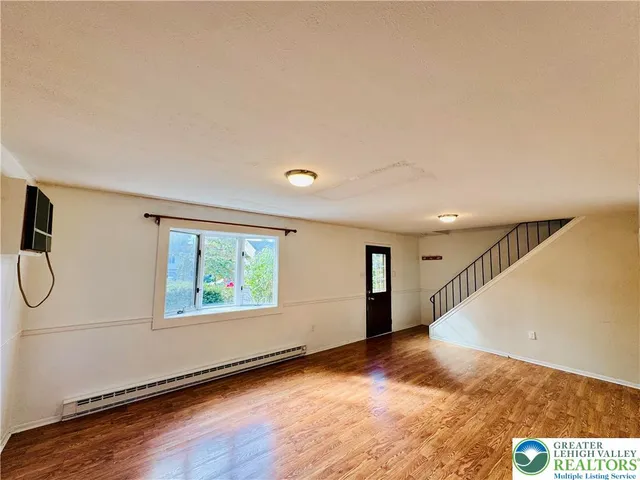 a view of a livingroom with wooden floor and window
