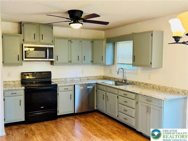 a kitchen with stainless steel appliances granite countertop a sink and a stove top oven