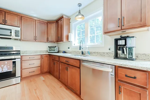 a kitchen with granite countertop cabinets stainless steel appliances a sink and window