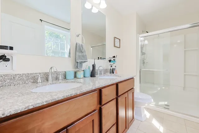 a bathroom with a granite countertop sink a mirror and a shower