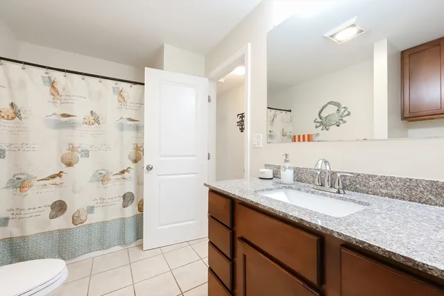 a bathroom with a granite countertop sink mirror toilet and shower
